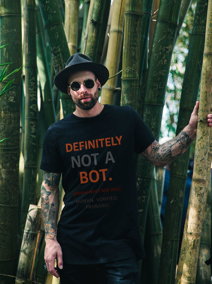 Man wearing a black t-shirt with 'DEFINITELY NOT A BOT' text in a bamboo forest